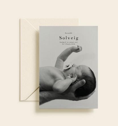 Personlig barnedåbsinvitation med stort sort-hvidt babyfoto.